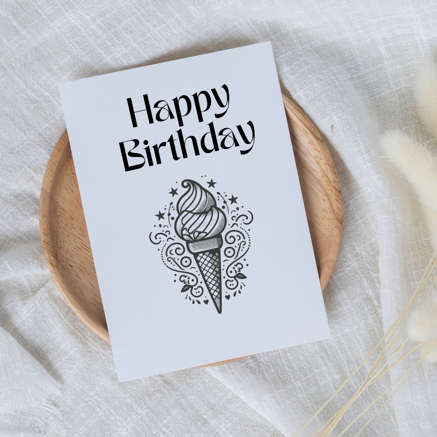 a birthday card with a clean and elegant design. The central graphic is a detailed ice cream cone with decorative elements such as stars and swirl patterns, rendered in a black and white silhouette style.