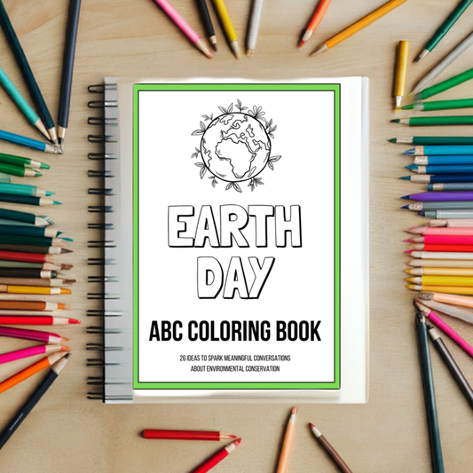 A photo of a coloring book titled "EARTH DAY ABC COLORING BOOK" with the subtitle "26 Ideas to Spark Meaningful Conversations about Environmental Conservation," featuring a line art illustration of Earth encircled by plants. The book is surrounded by a variety of colorful pencils on a wooden surface.