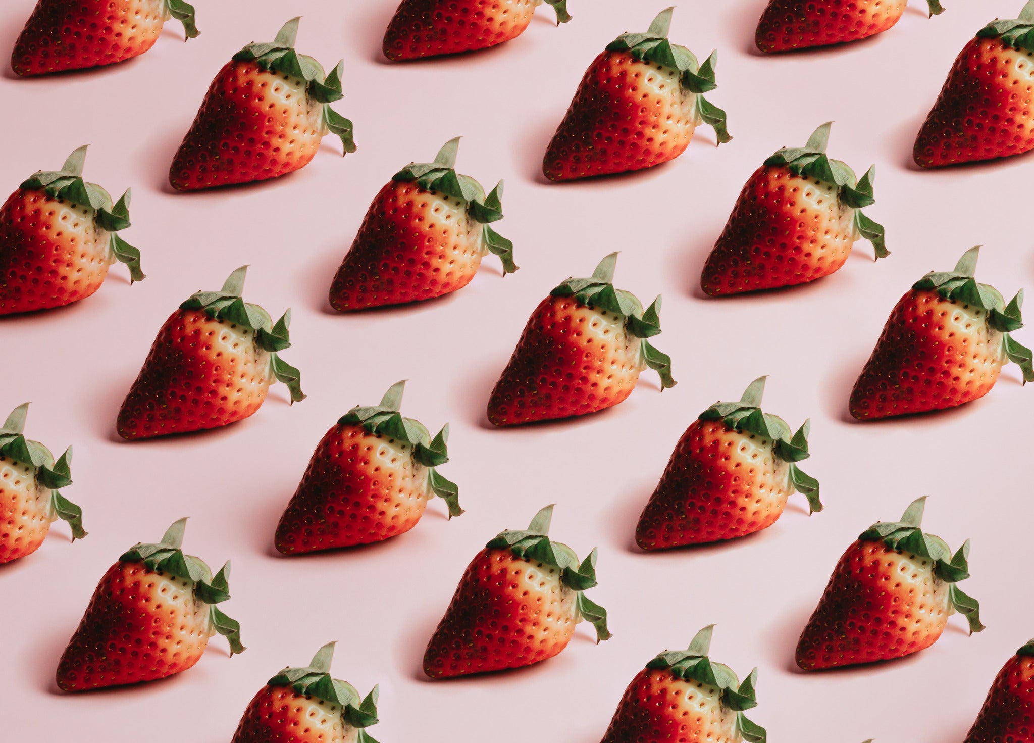 ripe red strawberries on a pink background